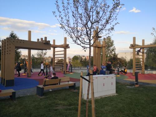 a playground with people sitting on benches in a park at Apartament Vultur - 3 rooms, 2 bathrooms in Târgu-Mureş