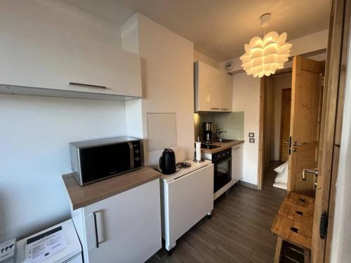 une cuisine avec un réfrigérateur et un micro-ondes dans l'établissement Résidence Alpinea - ALPINEA A4 MAE-4371, à Les Allues