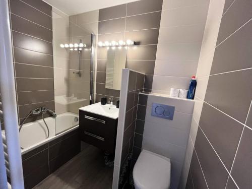 une salle de bain avec toilettes, baignoire et lavabo dans l'établissement Résidence Alpinea - ALPINEA A4 MAE-4371, à Les Allues