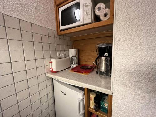 une petite cuisine avec un micro-ondes et un réfrigérateur dans l'établissement Résidence Candide - CANDIDE C11 MAE-4411, à Les Allues