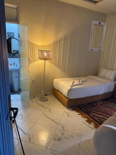 a bedroom with a bed and a glass shower at Playa Del Sol Surf House in Tamraght Ouzdar