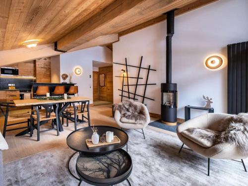 un salon avec une table et des chaises et une cheminée dans l'établissement Chalets De Tueda - LES CHALETS DE TUEDA 5 MAE-9301, à Les Allues