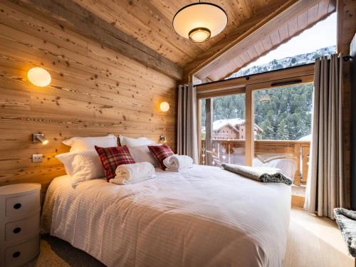 - une chambre avec un grand lit dans une pièce dotée d'une fenêtre dans l'établissement Chalets De Tueda - LES CHALETS DE TUEDA 5 MAE-9301, à Les Allues
