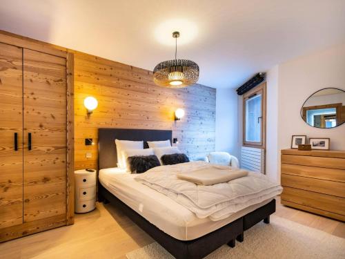 une chambre avec un grand lit avec un mur en bois dans l'établissement Chalets De Tueda - LES CHALETS DE TUEDA 3 MAE-9321, à Les Allues