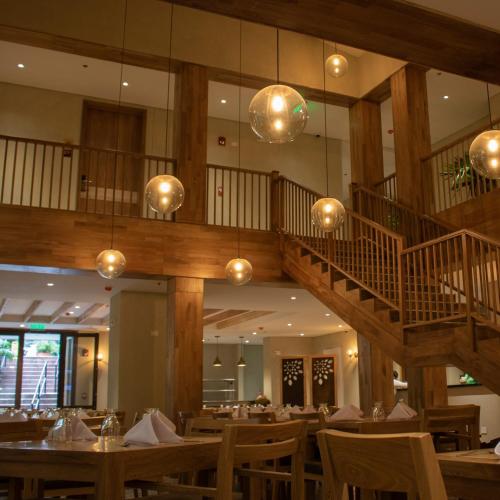 a dining room with tables and a staircase at Termales Santa Rosa De Cabal in Santa Rosa de Cabal