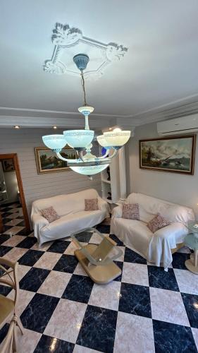 a living room with two couches and a chandelier at piso en arenas de velez malaga in Málaga