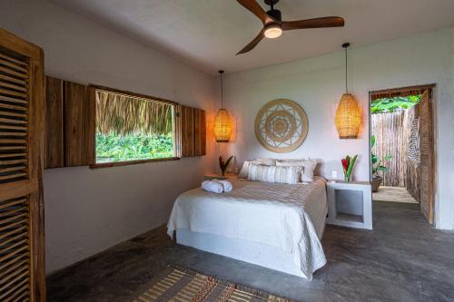 a bedroom with a bed and a ceiling fan at Arrecifes Refugio Natural in Santa Marta