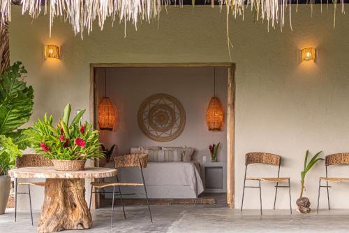 a bedroom with a bed and a table and chairs at Arrecifes Refugio Natural in Santa Marta