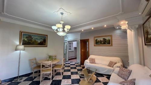 a living room with a table and chairs and a chandelier at piso en arenas de velez malaga in Málaga