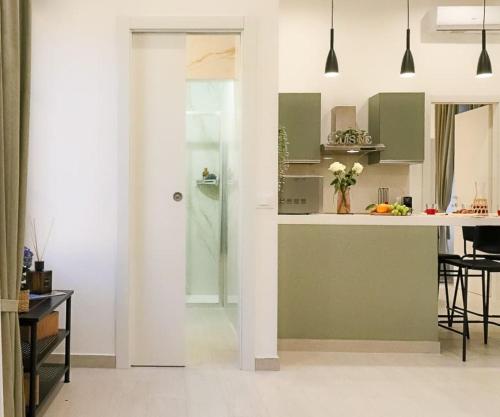a kitchen with green and white cabinets and a table at New private apt in Como whit A-C Comfort - Elegant - Comfortable in Como