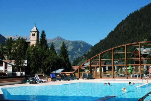 une grande piscine dans un complexe avec une montagne dans l'établissement Résidence Les Terrasses De La Vanoise - LES TERRASSES DE LA VANOISE B14 MAE-3751, à Champagny-en-Vanoise
