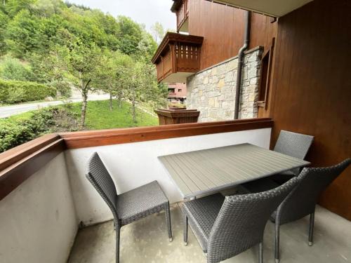 un balcon avec une table, des chaises et une fenêtre dans l'établissement Résidence Fermes De Meribel Bat B - Appartement 2 pièces 4 personnes à Méribel Village aux pieds des pistes et accès à la piscine chauffée MAE-8991, à Les Allues