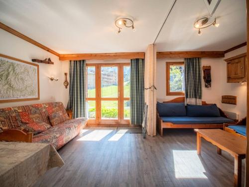 un salon avec un canapé et quelques fenêtres dans l'établissement Résidence Athamante G - ATHAMANTE 02 MAE-4771, à Valmorel