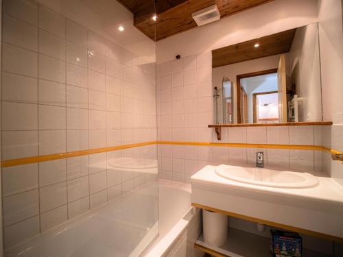 une salle de bain avec un lavabo, une baignoire et un miroir dans l'établissement Résidence Athamante G - ATHAMANTE 02 MAE-4771, à Valmorel