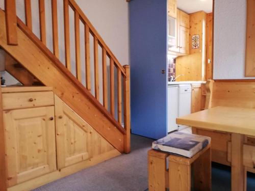 une cuisine avec un escalier en bois, un comptoir et une table dans l'établissement Résidence Cristallin G - CRISTALLIN 56 MAE-5901, à Valmorel