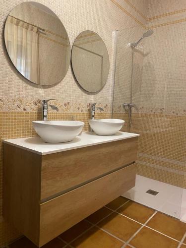 a bathroom with two sinks and two mirrors at Casa Loarre in La Iruela