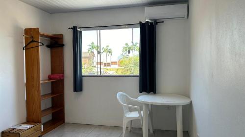a small room with a table and a window at Suíte Com Vista Privilegiada poucos minutos Vila Germânica Oktoberfest in Blumenau