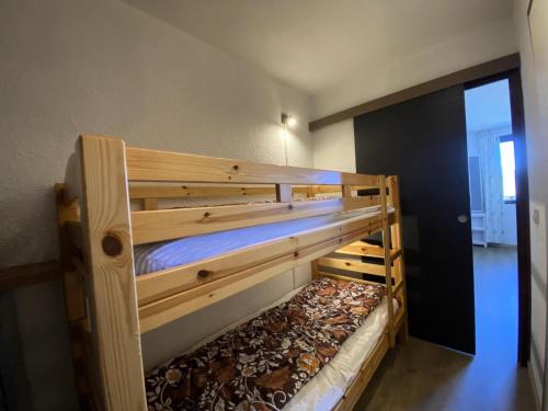 Ce lit superposé en bois se trouve dans un dortoir. dans l'établissement Résidence Le Cairn - Agréable studio 4 vue vallée aux Orres 1650 MAE-9121, aux Orres