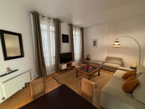 un salon avec un canapé et une table dans l'établissement Champs Elysées, à Paris