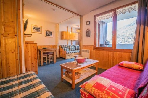 une chambre avec un lit, une table et une fenêtre dans l'établissement Résidence Bourgeon G - BOURGEON 09 MAE-6011, à Valmorel