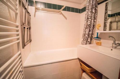 une salle de bain blanche avec une baignoire et un lavabo dans l'établissement Résidence Bourgeon G - BOURGEON 09 MAE-6011, à Valmorel
