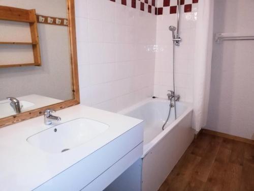 une salle de bain blanche avec un lavabo et une douche dans l'établissement Résidence Lauzes G - LAUZES 24 MAE-6031, à Valmorel