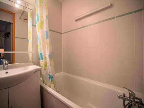 une salle de bain avec une baignoire blanche et un lavabo dans l'établissement Résidence Cheval Noir G - CHEVAL NOIR 16 MAE-6091, à Valmorel