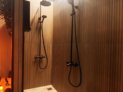 a shower stall with two shower heads and a shower at Love Room Luxure 50 Nuances in Jonzac