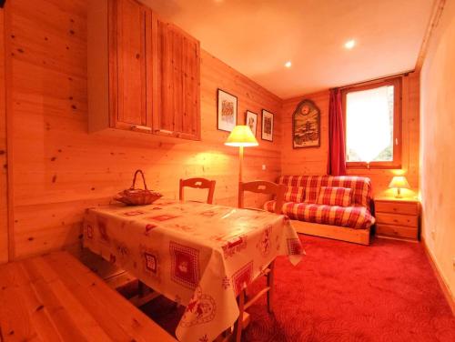 Cette chambre comprend une table, un canapé et une fenêtre. dans l'établissement Résidence Lisiere G - LISIERE 5 MAE-6231, à Valmorel