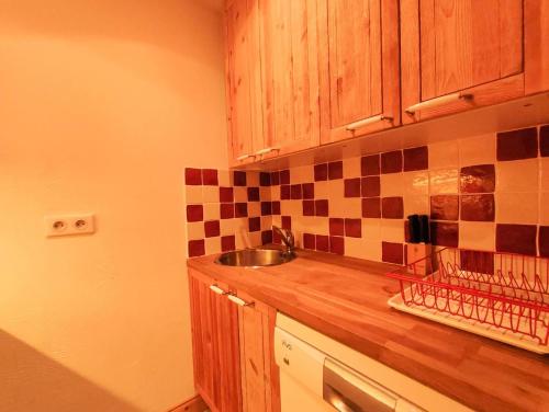 une cuisine avec des armoires en bois et un évier dans l'établissement Résidence Lisiere G - LISIERE 5 MAE-6231, à Valmorel
