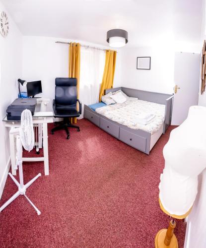 une chambre avec un lit et un bureau avec un ordinateur dans l'établissement L'Appart, au Plessis-Robinson