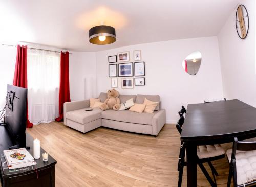 sala de estar con sofá y osito de peluche en L'Appart, en Le Plessis-Robinson