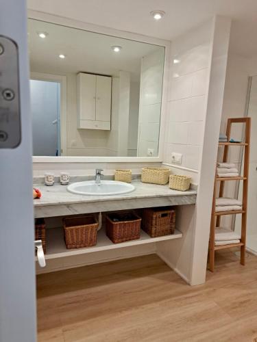 a bathroom with a sink and a large mirror at Blue Marlin 6 in Pasito Blanco
