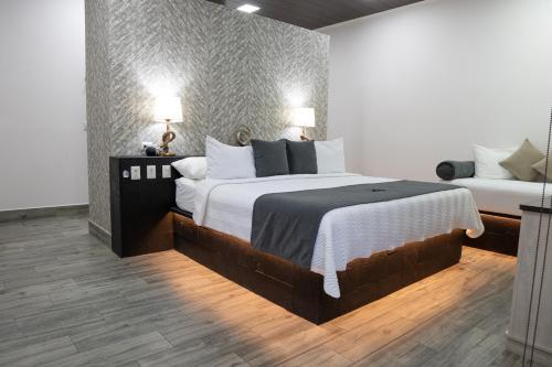 a bedroom with a large bed with two lamps at Hotel Boutique Casa Del Rio in Fortuna