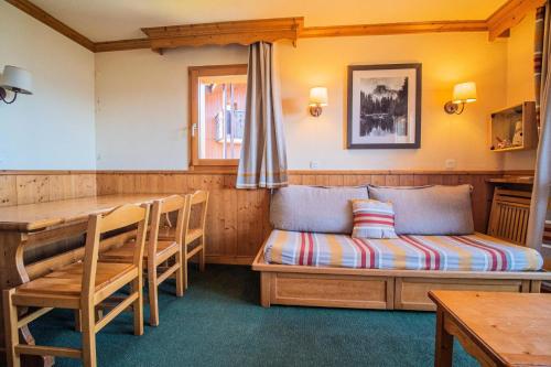 Cette chambre comprend un lit, une table et un banc. dans l'établissement Résidence Valeriane G - VALERIANE 220 MAE-6271, à Valmorel