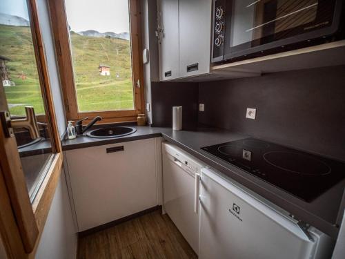 une petite cuisine avec un évier et une fenêtre dans l'établissement Résidence Cote Soleil G - COTE SOLEIL 37 MAE-6311, à Valmorel