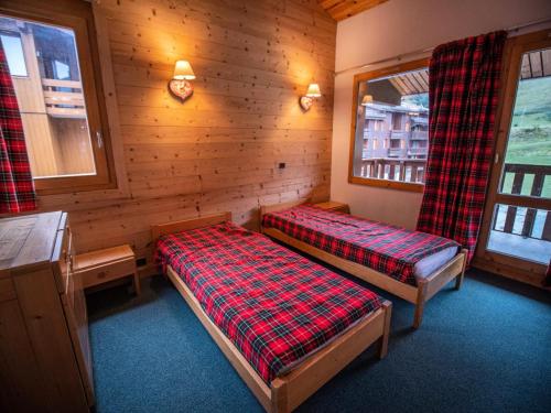 une chambre avec deux lits dans une cabane en rondins dans l'établissement Résidence Cote Soleil G - COTE SOLEIL 37 MAE-6311, à Valmorel