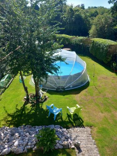 une tente, une table et une chaise dans la cour dans l'établissement Le meuble du pont, à Ferques