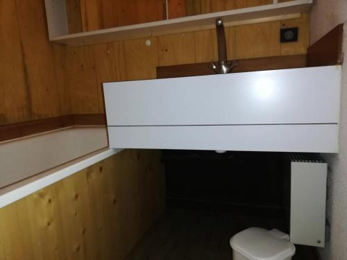 La salle de bains est pourvue de toilettes et d'une armoire blanche. dans l'établissement Résidence Cote Soleil G - COTE SOLEIL 41 MAE-6321, à Valmorel
