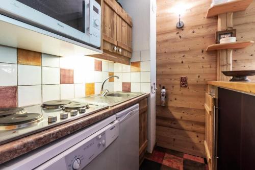 une cuisine avec une cuisinière et un évier dans l'établissement Résidence Camarine G - CAMARINE 40 MAE-6361, à Valmorel