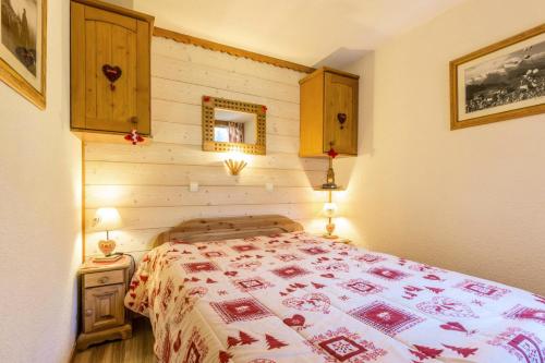 - une chambre dotée d'un lit avec une couverture rouge et blanche dans l'établissement Résidence Lauziere Dessus G - LAUZIERE DESSUS 12 MAE-6371, à Valmorel