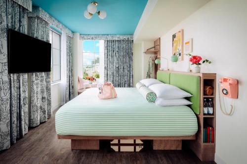 a bedroom with a large bed and a tv at The Goodtime Hotel, Miami Beach a Tribute Portfolio Hotel in Miami Beach