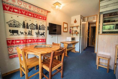 - une salle à manger avec deux tables et des chaises en bois dans l'établissement Résidence Cheval Blanc G - CHEVAL BLANC C63 MAE-6421, à Valmorel