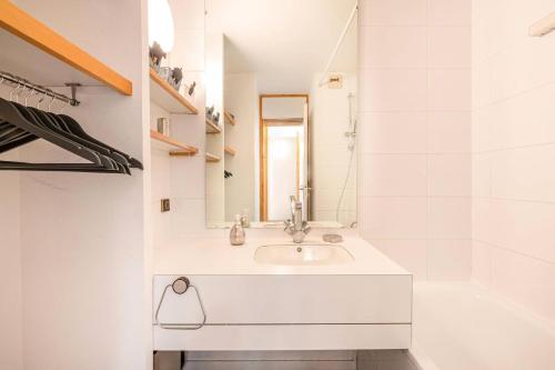 une salle de bain blanche avec un lavabo et un miroir dans l'établissement Résidence Roche Combe G - ROCHE COMBE 14 MAE-6451, à Valmorel