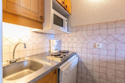 une cuisine avec un évier et un plan de travail dans l'établissement Résidence Roche Combe G - ROCHE COMBE 37 MAE-6461, à Valmorel