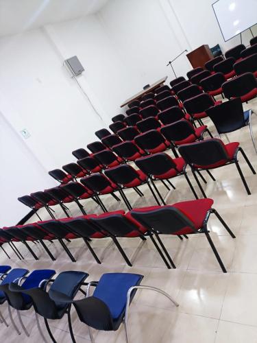 an empty lecture hall with red and blue chairs at Hotel Armenia Lions in Armenia