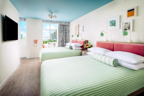 a room with two beds and a tv at The Goodtime Hotel, Miami Beach a Tribute Portfolio Hotel in Miami Beach