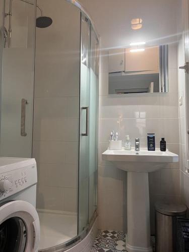 une salle de bain avec une douche en verre et un lavabo dans l'établissement Appartement Saint-Germain-Des-Prés, à Paris