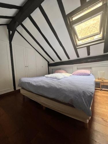 Ce lit se trouve dans un dortoir doté d'un plafond et d'une fenêtre. dans l'établissement Appartement Saint-Germain-Des-Prés, à Paris