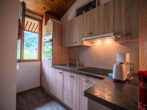 une cuisine avec des armoires en bois, un évier et une fenêtre dans l'établissement Résidence Pierrafort G - PIERRAFORT 48 MAE-6591, à Valmorel